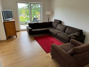 a living room with a black couch and a red rug at Hofberg Villa - Appartment in Landshut