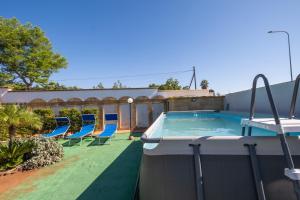 a swimming pool with blue chairs on a yard at Malva House in Villa Con Piscina in Torre Lapillo