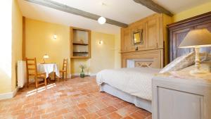 a bedroom with a bed and a table and chairs at Le Guitou de Monlezun in Monlezun