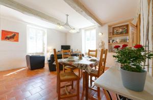 a living room with a dining room table and chairs at Le Guitou de Monlezun in Monlezun
