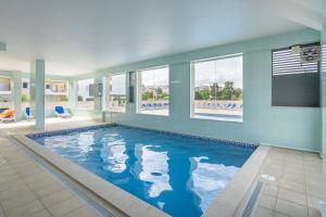 a large swimming pool in a room with windows at Palmeiras de jv in Lagos