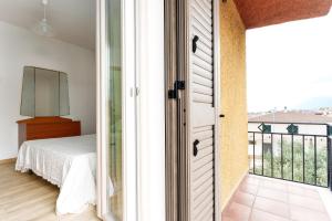 a bedroom with a bed and a view of a balcony at Cozy And Cool Flat in Orosei