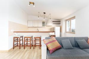 a living room with a couch and a kitchen at Cozy And Cool Flat in Orosei