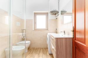 a bathroom with a toilet and a sink at Cozy And Cool Flat in Orosei +15 photos