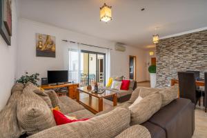 a living room with a couch and a tv at Palmeiras de jv in Lagos