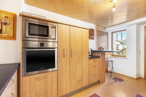 a kitchen with wooden cabinets and a microwave at Ferienwohnung Hewenpanorama 1 in Engen