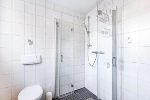 a white bathroom with a shower and a toilet at Ferienwohnung Hewenpanorama 1 in Engen +15 photos