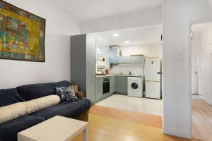 a living room with a couch and a kitchen at Bisa's house in Estoril +18 photos