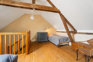 a attic room with a bed and a staircase at Gîte La Malcotais in Noyal-Châtillon-sur-Seich