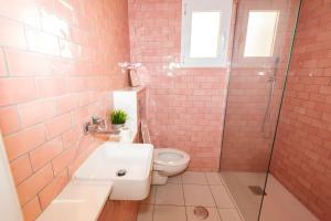 a bathroom with a toilet and a sink and a shower at Casa de Arte in Torrox