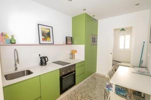 a kitchen with green cabinets and a sink at Casa de Arte in Torrox