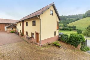 a house on a brick road next to a hill at Hof Helmenhube 1 in Oberzent