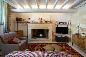 a living room with a fireplace and a bed at La dimora Elia' in Muro Leccese