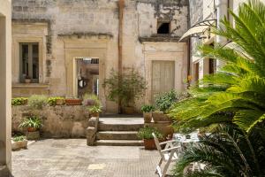 an old building with a bunch of potted plants at La dimora Elia' in Muro Leccese