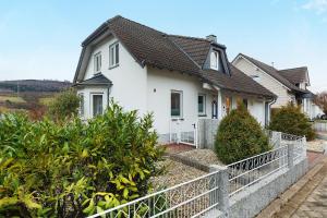 a white house with a fence in front of it at Ferienwohnung Ruhrtal in Bestwig