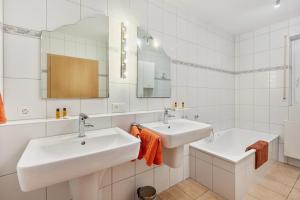 a white bathroom with two sinks and a mirror at Ferienwohnung Ruhrtal in Bestwig +36 photos
