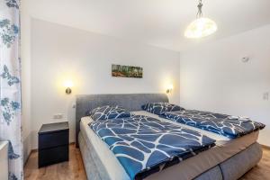 a bedroom with a bed with a blue and white comforter at Ferienwohnung Ruhrtal in Bestwig