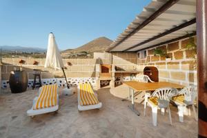 a patio with a table and chairs and an umbrella at Finca Eva in Granadilla de Abona