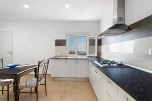 a kitchen with white cabinets and a black counter top at Finca Eva in Granadilla de Abona