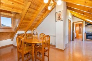 a dining room with a wooden table and chairs at La Golfa in Durro +11 photos