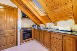 a kitchen with wooden cabinets and a stove top oven at La Golfa in Durro