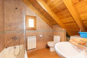 a bathroom with a toilet and a sink and a tub at La Golfa in Durro