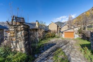 a stone wall with a sign on a street at La Golfa in Durro