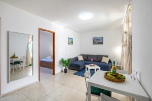 a living room with a blue couch and a table at Brisa de mar in Puerto Naos