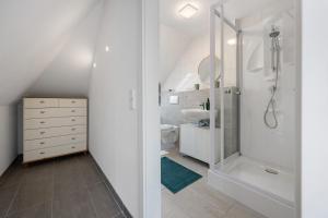 a white bathroom with a shower and a sink at Ferienwohnung 2 in Bad Salzuflen +15 photos