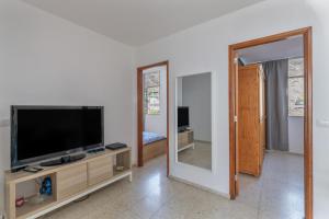 a living room with a flat screen tv and a mirror at Brisa de mar in Puerto Naos