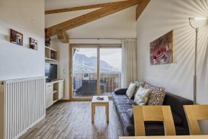 a living room with a couch and a large window at Feldhof Apartment Apfeltraum in Caines