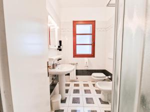 a white bathroom with a sink and a toilet at Casa Golfi di Lacona in Lacona