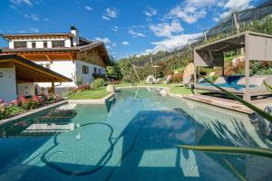 a swimming pool with blue water in a house at Feldhof Apartment Apfeltraum in Caines