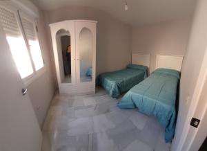 ein Zimmer mit zwei Betten und einem Spiegel in der Unterkunft Ático Bulevar in Macael