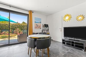ein Esszimmer mit einem Tisch und einem Fernseher in der Unterkunft Studio 890 in Lorgues