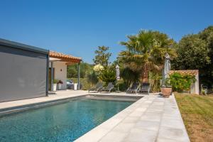 ein Swimmingpool im Garten mit Stühlen und einem Haus in der Unterkunft Studio 890 in Lorgues + 17 Fotos