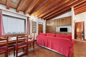 a living room with a red couch and a table at Au Petit Chevrot - Classic in Aosta
