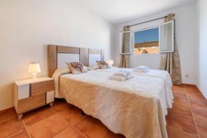 a bedroom with a large bed and a window at Estrella de mar verde in Port d'Alcudia +18 photos