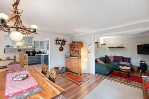 a living room with a green couch and a kitchen at Haus Ruheplatzerl in Ruhpolding