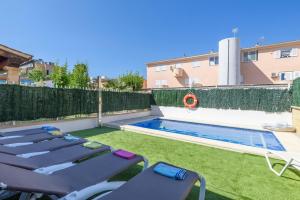 a backyard with lounge chairs and a swimming pool at Estrella de mar verde in Port d'Alcudia
