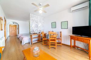 a living room with a bed and a dining room at Apartamento residencial Fénix in Roquetas de Mar