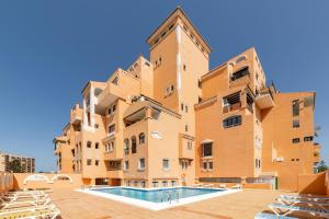 an apartment building with a swimming pool in front of it at Apartamento residencial Fénix in Roquetas de Mar