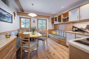 a kitchen and dining room with a table and chairs at Bergblick App Fichte in Villnoss
