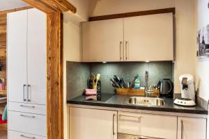 a kitchen with white cabinets and a sink at Haus Excelsior Top 36 in Seefeld in Tirol +10 photos