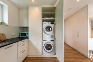 a kitchen with a washer and dryer at Fewo Parkside S3 - 8Min Legoland in Günzburg