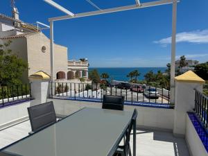 a balcony with a table and chairs and the ocean at Casa Blanca in Torrox Costa