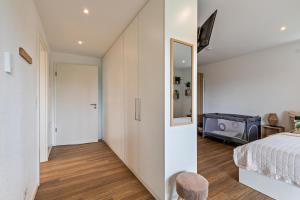 a bedroom with a bed and a room with a mirror at Fewo Parkside S3 - 8Min Legoland in Günzburg