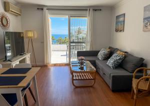 a living room with a couch and a table at Casa Blanca in Torrox Costa +4 photos