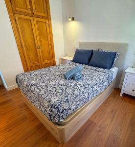 a bedroom with a bed with blue pillows at Casa Blanca in Torrox Costa