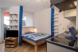 a small room with a bed and a kitchen at Ferienwohnung Förster in Überlingen
